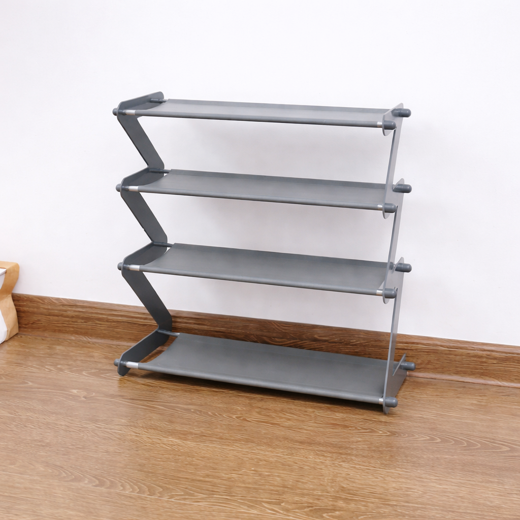 Gray metal shelf with four shelves on a wooden floor against a white wall.