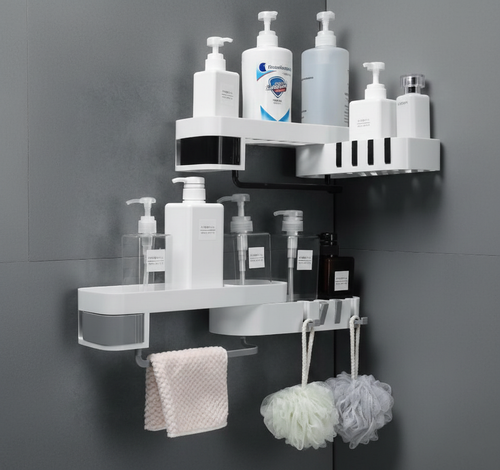 White corner shower caddy with various bottles and bath products on a gray wall.